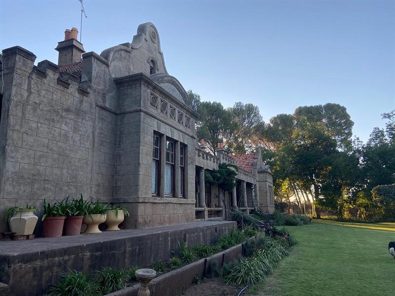 The castellated stone parapet and shaped gable on the side of the house, in evening light