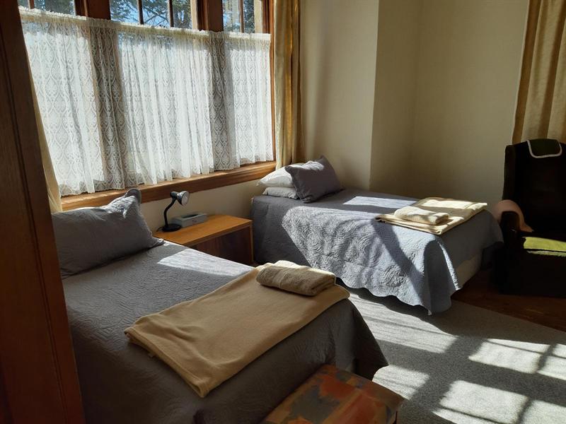 The Family Suite's second room, with two single beds beside a lace-curtained window