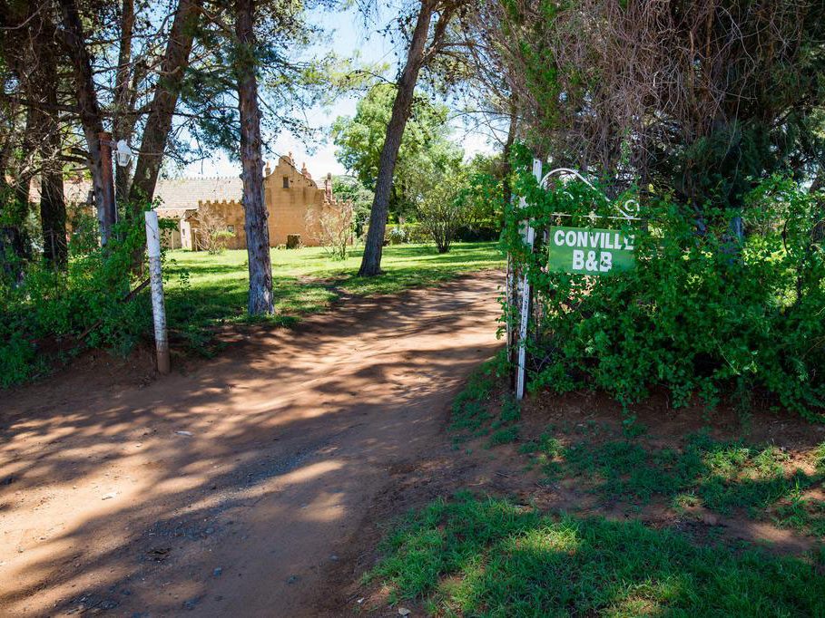 The Conville B&B sign at the farm gate, on a shaded dirt road