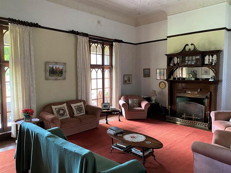 The sitting room with armchairs and sofas around a fireplace
