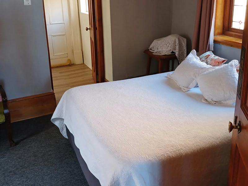 The Garden Room: a double bed under a white quilted cover, with a door through to its own shower room